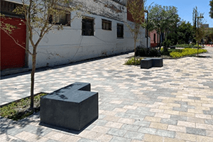 bancas de concreto para jardin tipo escuadra en un parque con arboles